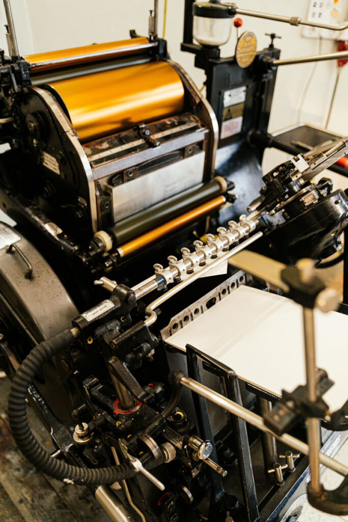 Foil printing press printing gold foil wedding invitations. Full service wedding invitations, stationery, and signage