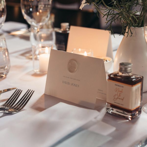oversized place cards and personalised menus styled at wedding reception table with candles and flowers