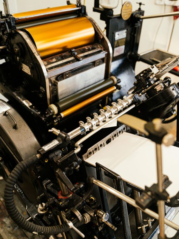Foil printing press printing gold foil wedding invitations. Full service wedding invitations, stationery, and signage